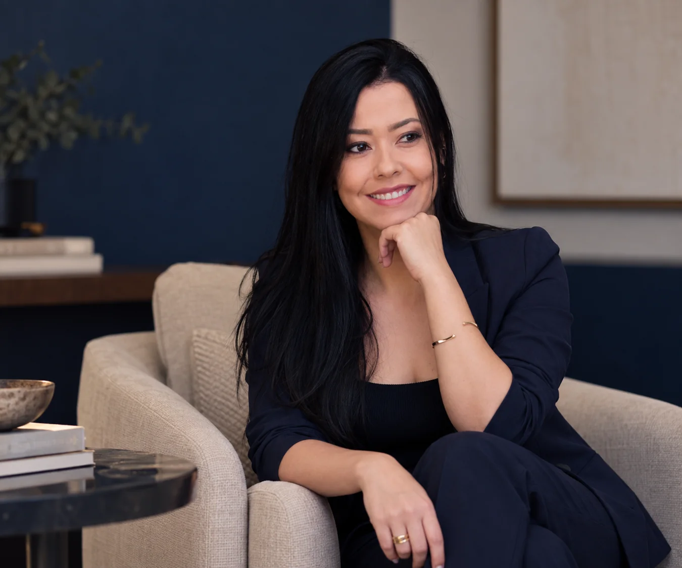 Katia Vicente sentada em uma poltrona